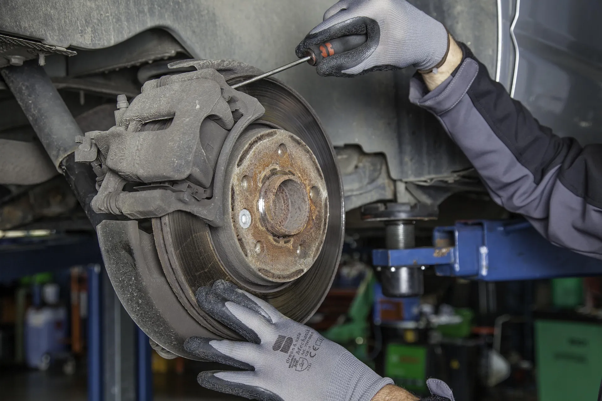 Monteur met gereedschap aan het werk bij de remschijf